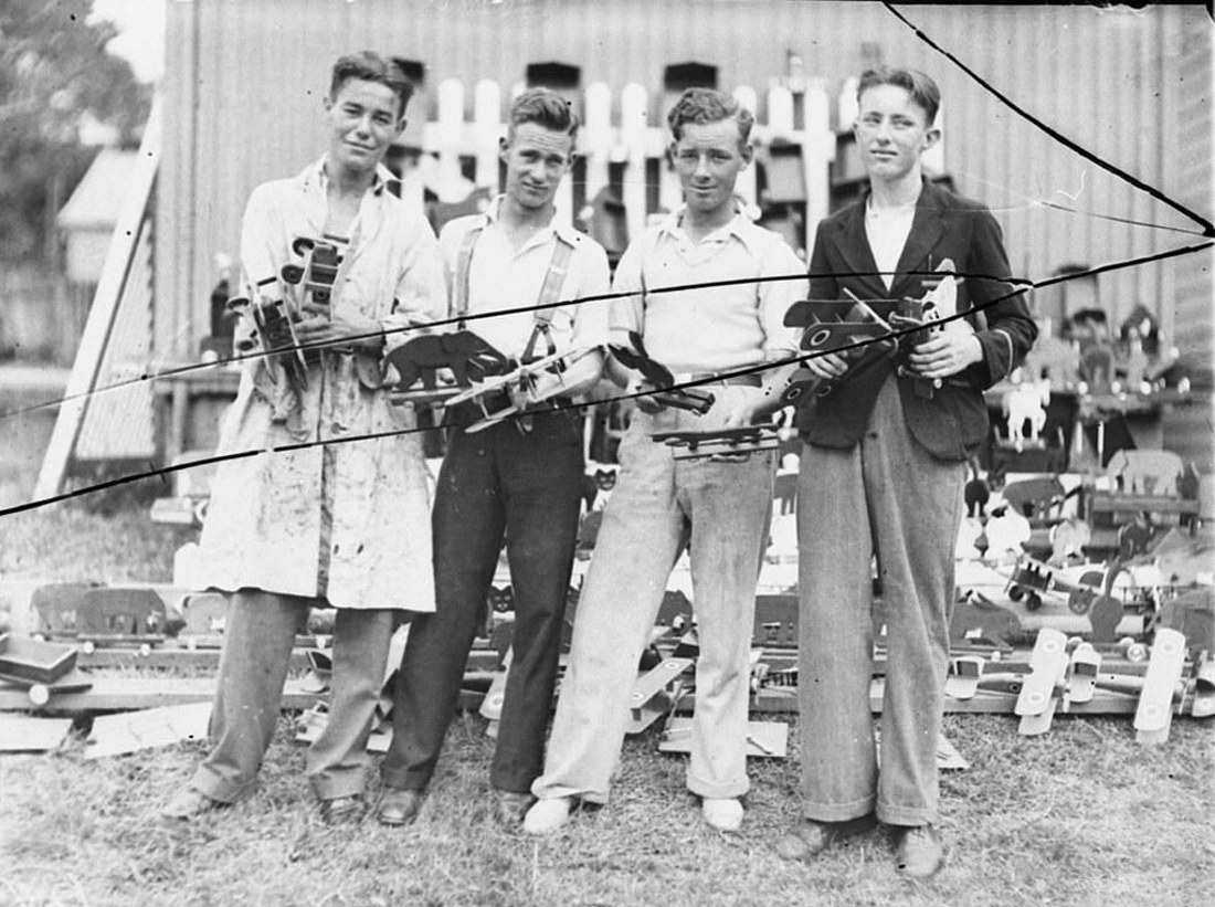 Four young men holding toy aeroplanes, 1934, before
